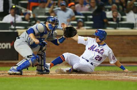 NEW YORK, NY – SEPTEMBER 15: J.D. Davis #28 of the New York Mets scores before the tag of catcher Will Smith #16 of the Los Angeles Dodgers on a two-run triple by Brandon Nimmo #9 during the second inning of a game at Citi Field on September 15, 2019 in New York City. (Photo by Rich Schultz/Getty Images)