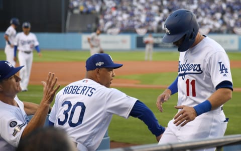 LOS ANGELES, CALIFORNIA – OCTOBER 03: Manager Dave Roberts of the Los Angeles Dodgers congratulates A.J. Pollock #11 after he scored on a walk by Max Muncy #13 in the first inning of game one of the National League Division Series against the Washington Nationals at Dodger Stadium on October 03, 2019 in Los Angeles, California. (Photo by Harry How/Getty Images)