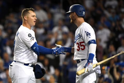 LOS ANGELES, CALIFORNIA – OCTOBER 03: Joc Pederson #31 of the Los Angeles Dodgers celebrates with Cody Bellinger #35 after his solo home run in the eighth inning of game one of the National League Division Series against the Washington Nationals to make it 6-0 at Dodger Stadium on October 03, 2019 in Los Angeles, California. (Photo by Harry How/Getty Images)