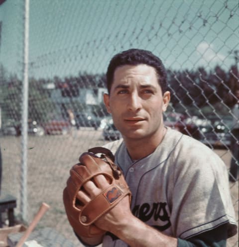 American baseball player Carl Furillo (1922- 1989), in the uniform of the Brooklyn Dodgers, poses with a baseball glove near a chain-link fence, mid 1950s. (Photo by Hulton Archive/Getty Images)