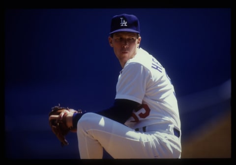 Orel Hershiser of the Los Angeles Dodgers stares at home plate while in the middle of his wind up