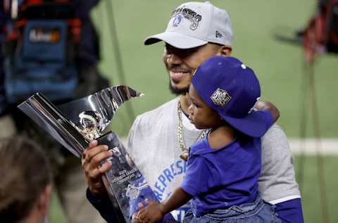 ARLINGTON, TEXAS - OCTOBER 18: Mookie Betts #50 of the Los Angeles Dodgers celebrates with his child following the teams 4-3 victory against the Atlanta Braves in Game Seven of the National League Championship Series at Globe Life Field on October 18, 2020 in Arlington, Texas. (Photo by Tom Pennington/Getty Images)