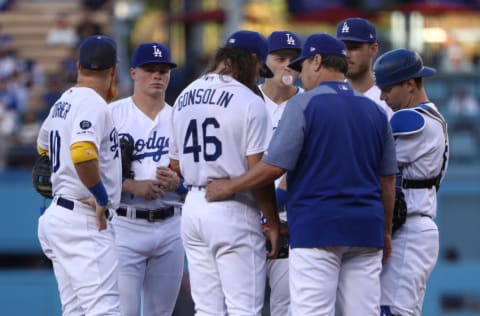 LOS ANGELES, CALIFORNIA - SEPTEMBER 07: Pitching coach Rick Honeycutt #40 of the Los Angeles Dodgers visits the mound to talk with pitcher Tony Gonsolin #46 as teammates Justin Turner #10, Gavin Lux #48, Corey Seager #5, Cody Bellinger #35 and catcher Will Smith #16 look on during the first inning of the MLB game against the San Francisco Giants at Dodger Stadium on September 07, 2019 in Los Angeles, California. The Giants defeated the Dodgers 1-0. (Photo by Victor Decolongon/Getty Images)