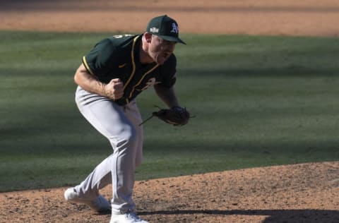 LOS ANGELES, CALIFORNIA - OCTOBER 07: Liam Hendriks #16 of the Oakland Athletics reacts to striking out Josh Reddick #22 of the Houston Astros to end the eighth inning in Game Three of the American League Division Series at Dodger Stadium on October 07, 2020 in Los Angeles, California. (Photo by Harry How/Getty Images)