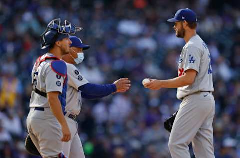 DENVER, CO - APRIL 1: Clayton Kershaw #22 of the Los Angeles Dodgers hands the baseball to Manager Dave Roberts as hes removed from the game in the sixth inning as catcher Austin Barnes #15 looks on against the Colorado Rockies on Opening Day at Coors Field on April 1, 2021 in Denver, Colorado. (Photo by Justin Edmonds/Getty Images)