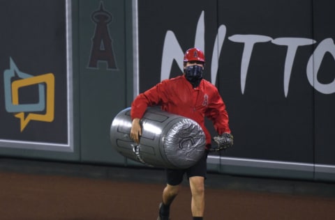 ANAHEIM, CALIFORNIA - APRIL 05: A member of the Los Angeles Angels grounds crew removes an inflated plastic trash can thrown on to the field during the sixth inning against the Houston Astros at Angel Stadium of Anaheim on April 05, 2021 in Anaheim, California. (Photo by Harry How/Getty Images)