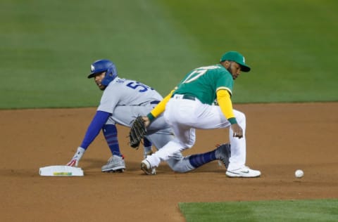 OAKLAND, CALIFORNIA - APRIL 06: Mookie Betts #50 of the Los Angeles Dodgers is safe at second base as Elvis Andrus #17 of the Oakland Athletics was unable to secure the ball int the top of the fourth inning at RingCentral Coliseum on April 06, 2021 in Oakland, California. (Photo by Lachlan Cunningham/Getty Images)