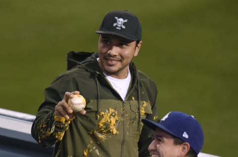 LOS ANGELES, CALIFORNIA - APRIL 14: A fan holds up the homerun ball of Justin Turner #10 of the Los Angeles Dodgers which landed in his nachos during the third inning against the Colorado Rockies at Dodger Stadium on April 14, 2021 in Los Angeles, California. (Photo by Harry How/Getty Images)