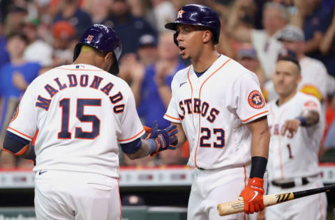 HOUSTON, TEXAS - JUNE 16: Michael Brantley #23 of the Houston Astros reacts to Martin Maldonado #15 hitting a home run during the second inning against the Texas Rangers at Minute Maid Park on June 16, 2021 in Houston, Texas. (Photo by Carmen Mandato/Getty Images)