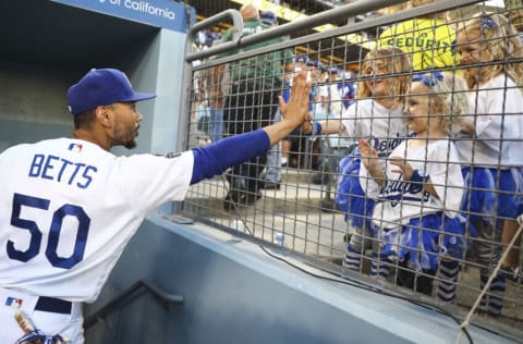 LOS ANGELES, CALIFORNIA - JUNE 26: Mookie Betts #50 of the Los Angeles Dodgers high fives with fans after the game against the Chicago Cubs at Dodger Stadium on June 26, 2021 in Los Angeles, California. The Dodgers defeated the Cubs 3-2. (Photo by Meg Oliphant/Getty Images)