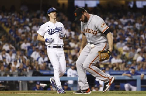 LOS ANGELES, CALIFORNIA - JUNE 29: Walker Buehler #21 of the Los Angeles Dodgers runs to first as Darin Ruf #33 of the San Francisco Giants defends during the fourth inning at Dodger Stadium on June 29, 2021 in Los Angeles, California. (Photo by Michael Owens/Getty Images)