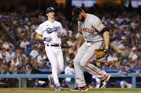 LOS ANGELES, CALIFORNIA - JUNE 29: Walker Buehler #21 of the Los Angeles Dodgers runs to first as Darin Ruf #33 of the San Francisco Giants defends during the fourth inning at Dodger Stadium on June 29, 2021 in Los Angeles, California. (Photo by Michael Owens/Getty Images)