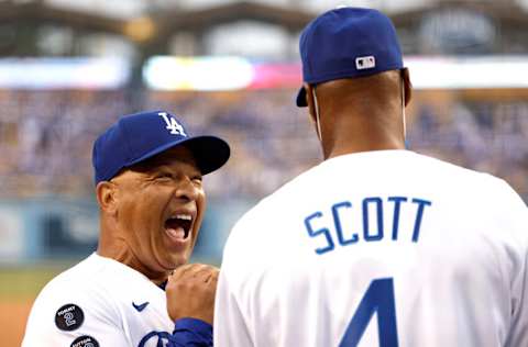 OS ANGELES, CALIFORNIA - AUGUST 31: Manager Dave Roberts #30 of the Los Angeles Dodgers (L) shares a moment with Former NBA player and coach Byron Scott (R) prior to a game between the Los Angeles Dodgers and the Atlanta Braves at Dodger Stadium on August 31, 2021 in Los Angeles, California. (Photo by Michael Owens/Getty Images)