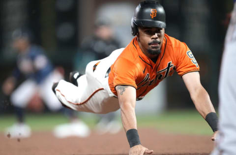 SAN FRANCISCO, CALIFORNIA - SEPTEMBER 17: LaMonte Wade Jr. #31 of the San Francisco Giants dives into third base safe against the Atlanta Braves in the bottom of the six inning at Oracle Park on September 17, 2021 in San Francisco, California. (Photo by Thearon W. Henderson/Getty Images)