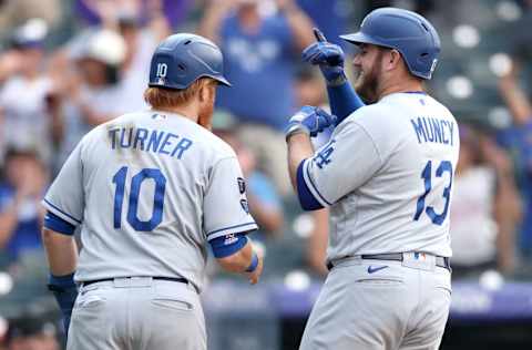 DENVER, COLORADO - SEPTEMBER 23: Max Muncy #13 of the Los Angeles Dodgers is congratulated by Justin Turner #10 as he heads to the dugout after hitting a 2 RBI home run against the Colorado Rockies in the tenth inning at Coors Field on September 23, 2021 in Denver, Colorado. (Photo by Matthew Stockman/Getty Images)