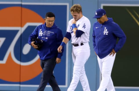 LOS ANGELES, CALIFORNIA - SEPTEMBER 29: Gavin Lux #9 of the Los Angeles Dodgers leaves the field with Dave Roberts #30 and medical staff after an injury against the wall on a Wil Myers #5 of the San Diego Padres triple during the sixth inning at Dodger Stadium on September 29, 2021 in Los Angeles, California. (Photo by Harry How/Getty Images)