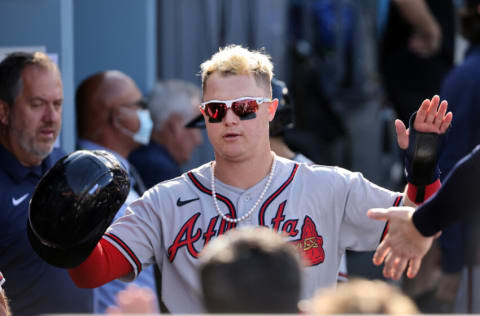 LOS ANGELES, CALIFORNIA - OCTOBER 19: Joc Pederson #22 of the Atlanta Braves is congratulated by teammates in the dugout after scoring during the 4th inning of Game 3 of the National League Championship Series against Los Angeles Dodgers at Dodger Stadium on October 19, 2021 in Los Angeles, California. (Photo by Harry How/Getty Images)