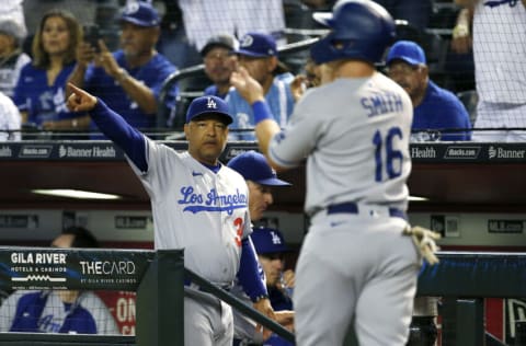 PHOENIX, ARIZONA - SEPTEMBER 24: Manager Dave Roberts #30 of the Los Angeles Dodgers points to first base as Will Smith #16 of the Dodgers scores against the Arizona Diamondbacks on a RBI single by Justin Turner of the Dodgers during the second inning of the MLB game at Chase Field on September 24, 2021 in Phoenix, Arizona. (Photo by Ralph Freso/Getty Images)