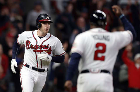 ATLANTA, GEORGIA - OCTOBER 31: Freddie Freeman #5 of the Atlanta Braves is congratulated by Eric Young Sr. #2 after hitting a solo home run against the Houston Astros during the third inning in Game Five of the World Series at Truist Park on October 31, 2021 in Atlanta, Georgia. (Photo by Elsa/Getty Images)