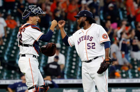 HOUSTON, TEXAS - AUGUST 21: Pedro Baez #52 of the Houston Astros bumps fists with Jason Castro #18 after they defeated the Seattle Mariners 15-1 at Minute Maid Park on August 21, 2021 in Houston, Texas. (Photo by Bob Levey/Getty Images)