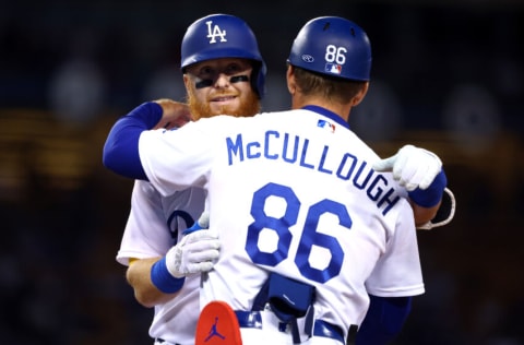 LOS ANGELES, CALIFORNIA - SEPTEMBER 20: Justin Turner #10 of the Los Angeles Dodgers hugs first base coach Clayton McCullough #86 during the fourth inning against the Arizona Diamondbacks in game two of a doubleheader at Dodger Stadium on September 20, 2022 in Los Angeles, California. (Photo by Katelyn Mulcahy/Getty Images)