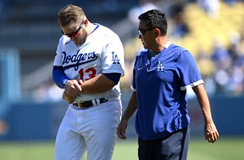 Oct 3, 2021; Los Angeles, California, USA; Los Angeles Dodgers first baseman Max Muncy (13) leaves the game after he injured his left arm making a tag on Milwaukee Brewers second baseman Jace Peterson (not pictured) in the third inning at Dodger Stadium. Mandatory Credit: Jayne Kamin-Oncea-USA TODAY Sports