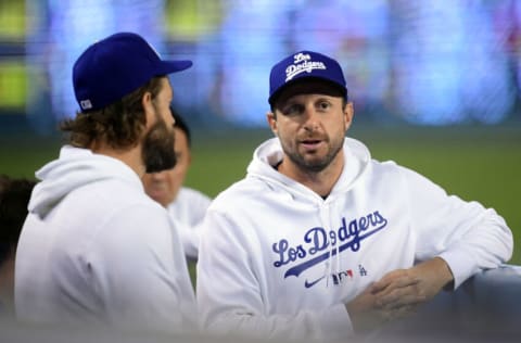 Sep 28, 2021; Los Angeles, California, USA; Los Angeles Dodgers starting pitcher Max Scherzer (31) speaks with starting pitcher Clayton Kershaw (22) during the third inning at Dodger Stadium. Mandatory Credit: Gary A. Vasquez-USA TODAY Sports