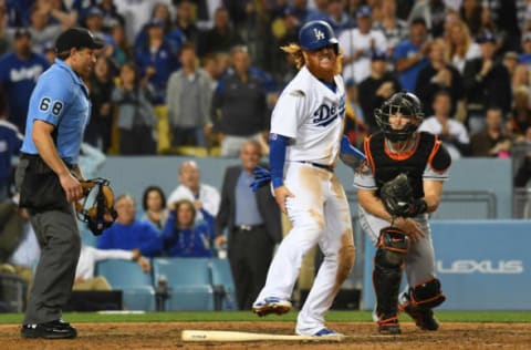 May 18, 2017; Los Angeles, CA, USA; Los Angeles Dodgers third baseman Justin Turner (10) reacts after being tagged out by Miami Marlins catcher J.T. Realmuto (11) at home plate as he tries to score on a hit by Dodgers catcher Yasmani Grandal (not pictured) in the seventh inning at Dodger Stadium. Turner left the game after suffering an apparent injury. Mandatory Credit: Richard Mackson-USA TODAY Sports