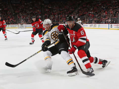 NEWARK, NEW JERSEY – MARCH 21: Chris Wagner #14 of the Boston Bruins and Andy Greene #6 of the New Jersey Devils battle for position during the first period at the Prudential Center on March 21, 2019 in Newark, New Jersey. (Photo by Bruce Bennett/Getty Images)