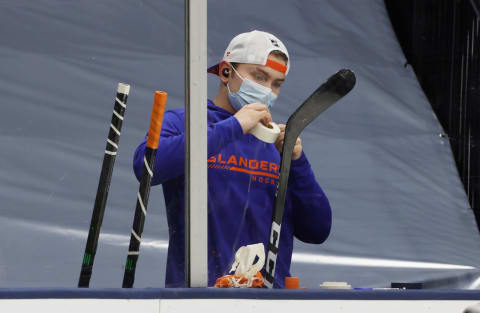 UNIONDALE, NEW YORK – JANUARY 21: Kieffer Bellows #20 of the New York Islanders prepares his sticks prior to the game against the New Jersey Devils at Nassau Coliseum on January 21, 2021 in Uniondale, New York. (Photo by Bruce Bennett/Getty Images)