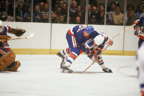 Swediah hockey player Stefan Persson of the New York Islanders uses his entire body to block New York Ranger Eddie Johnstone during a game at Madison Square Garden, New York, New York, late 1970s (Photo by Melchior DiGiacomo/Getty Images)