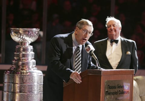 UNIONDALE, NY – MARCH 4: Former coach Al Arbour addresses the crowd as former GM Bill Torrey (R) looks on during a ceremony honoring the 25th anniversary of the New York Islanders first Stanley Cup victory, before the Islanders game against the Philadelphia Flyers on March 4, 2006 at the Nassau Coliseum in Uniondale, New York. (Photo by Bruce Bennett/Getty Images)