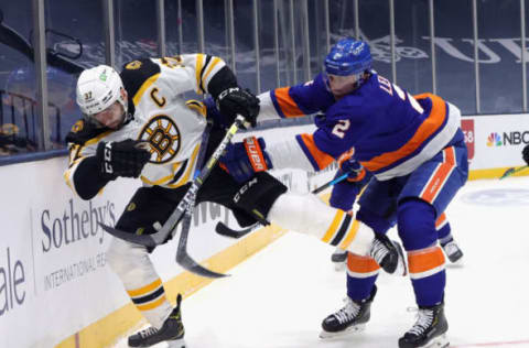 Nick Leddy #2 of the New York Islanders checks Patrice Bergeron #37 of the Boston Bruins. (Photo by Bruce Bennett/Getty Images)