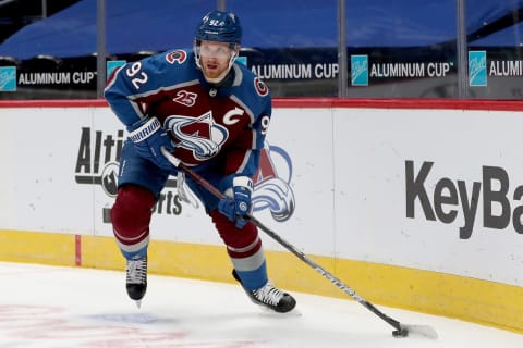 DENVER, COLORADO – JANUARY 26: Gabriel Landeskog #92 of the Colorado Avalanche brings the puck off the boards against the San Jose Sharks in the second period at Ball Arena on January 26, 2021 in Denver, Colorado. (Photo by Matthew Stockman/Getty Images)