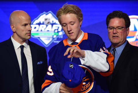 Simon Holmstrom puts on a cap and jersey after being selected by the New York Islanders. (Mandatory Credit: Anne-Marie Sorvin-USA TODAY Sports)