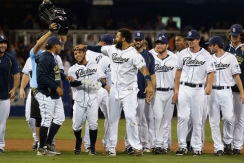 Sep 24, 2015; San Diego, CA, USA; San Diego Padres shortstop Alexi Amarista (5) gets a pat on the head from right fielder Matt Kemp (27) after driving in the winning run on an RBI single against the San Francisco Giants at Petco Park. Mandatory Credit: Jake Roth-USA TODAY Sports