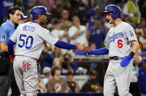 SAN DIEGO, CALIFORNIA - OCTOBER 15: Mookie Betts #50 and Trea Turner #6 of the Los Angeles Dodgers celebrate scoring runs on a two-run RBI double hit by Freddie Freeman #5 during the third inning against the San Diego Padres in game four of the National League Division Series at PETCO Park on October 15, 2022 in San Diego, California. (Photo by Harry How/Getty Images)