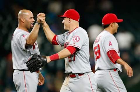 May 14, 2016; Seattle, WA, USA; Los Angeles Angels center fielder Mike Trout (C) celebrates with designated hitter Albert Pujols (L) after defeating the Seattle Mariners 9-7 at Safeco Field. Pujols provided the decisive blow with a 9th inning three-run homer. Mandatory Credit: Jennifer Buchanan-USA TODAY Sports