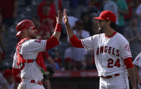 ANAHEIM, CALIFORNIA – APRIL 07: Relief pitcher Noe Ramirez #24 and catcher Jonathan Lucroy #20 of the Los Angeles Angels of Anaheim celebrate with a high-five after a 7-2 win against the Texas Rangers at Angel Stadium of Anaheim on April 07, 2019 in Anaheim, California. The Angels defeated the Rangers 7-2. (Photo by Victor Decolongon/Getty Images)