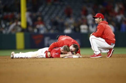 ANAHEIM, CALIFORNIA – APRIL 22: Zack Cozart #7 is attended to at second base by a trainer and head coach Brad Ausmus of the Los Angeles Angels of Anaheim after being injured at second base during the twelfth inning of a game against the New York Yankees at Angel Stadium of Anaheim on April 22, 2019 in Anaheim, California. (Photo by Sean M. Haffey/Getty Images)