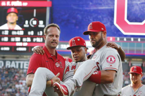 CLEVELAND, OH – AUGUST 03: Albert Pujols #5 helps carry Felix Pena #64 of the Los Angeles Angels of Anaheim off the field after he was injured covering first base to retire Jose Ramirez of the Cleveland Indians in the second inning at Progressive Field on August 3, 2019 in Cleveland, Ohio. (Photo by David Maxwell/Getty Images)