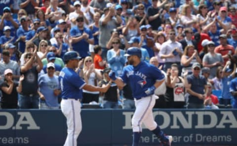 TORONTO, ON – AUGUST 22: Kendrys Morales #8 of the Toronto Blue Jays is congratulated by third base coach Luis Rivera #4 after hitting a solo home run in the seventh inning during MLB game action against the Baltimore Orioles at Rogers Centre on August 22, 2018 in Toronto, Canada. (Photo by Tom Szczerbowski/Getty Images)