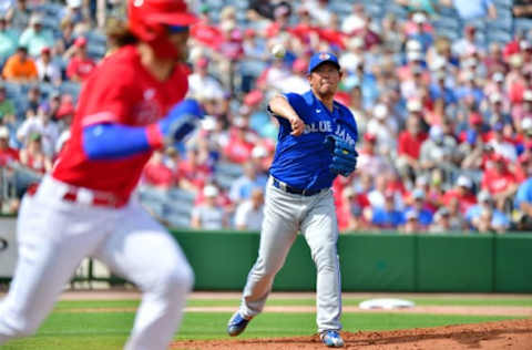 CLEARWATER, FLORIDA – MARCH 05: Shun Yamaguchi #1 of the Toronto Blue Jays throws to first before Bryce Harper #3 of the Philadelphia Phillies can make the tag during the third inning of a Grapefruit League spring training game at Spectrum Field on March 05, 2020 in Clearwater, Florida. (Photo by Julio Aguilar/Getty Images)