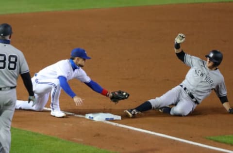 BUFFALO, NY – SEPTEMBER 22: DJ LeMahieu #26 of the New York Yankees slides safely into third base as Cavan Biggio #8 of the Toronto Blue Jays misses the tag during the fifth inning at Sahlen Field on September 22, 2020 in Buffalo, New York. The Blue Jays are the home team due to the Canadian government’s policy on COVID-19, which prevents them from playing in their home stadium in Canada. (Photo by Timothy T Ludwig/Getty Images)