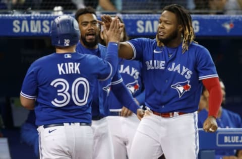 TORONTO, ON – SEPTEMBER 13: Alejandro Kirk #30 of the Toronto Blue Jays is welcomed to the dugout by Vladimir Guerrero Jr. #27 as he scores in the fourth inning of their MLB game off a Randal Grichuk #15 double against the Tampa Bay Rays at Rogers Centre on September 13, 2021 in Toronto, Ontario. (Photo by Cole Burston/Getty Images)