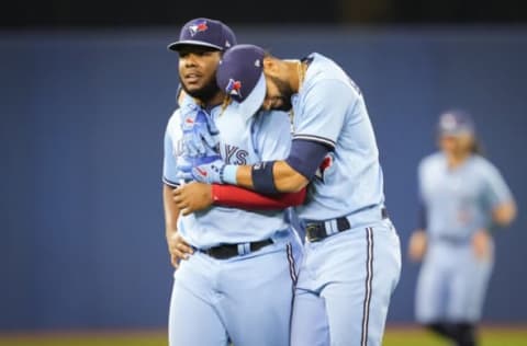 TORONTO, ONTARIO – OCTOBER 3: Vladimir Guerrero Jr. #27 and Lourdes Gurriel Jr. #13 of the Toronto Blue Jays hug during warm up before playing the Baltimore Orioles in their MLB game at the Rogers Centre on October 3, 2021 in Toronto, Ontario, Canada. (Photo by Mark Blinch/Getty Images)