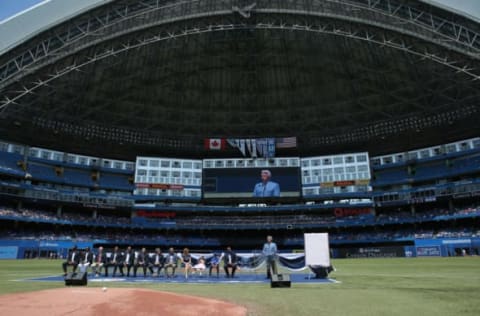 TORONTO, CANADA – JULY 21: Former player Carlos Delgado #25 of the Toronto Blue Jays sits with his wife and two kids as he is honored in a pre-game ceremony placing his name on The Level of Excellence as Nadir Mohamed, Paul Beeston, Alex Anthopoulos, Cito Gaston, Roberto Alomar, Pat Gillick, Tony Fernandez and George Bell look on while Buck Martinez speaks before MLB game action against the Tampa Bay Rays on July 21, 2013 at Rogers Centre in Toronto, Ontario, Canada. (Photo by Tom Szczerbowski/Getty Images)