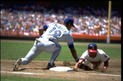 LUIS POLONIA OF THE CALIFORNIA ANGELS AVOIDS THE TAG OF TORONTO BLUE JAYS FIRST BASEMAN FRED MCGRIFF AT ANAHEIM STADIUM IN ANAHEIM, CALIFORNIA. MANDATORY CREDIT: STEPHEN DUNN/ALLSPORT