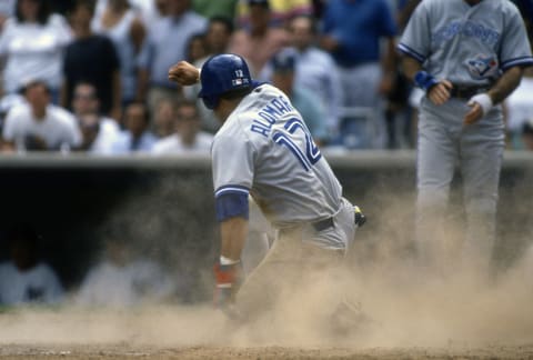 NEW YORK – CIRCA 1993: Roberto Alomar #12 of the Toronto Blue Jays scores against the New York Yankees during a Major League Baseball game circa 1993 at Yankee Stadium in the Bronx borough of New York City. Alomar played for the Blue Jays in 1991-95. (Photo by Focus on Sport/Getty Images)