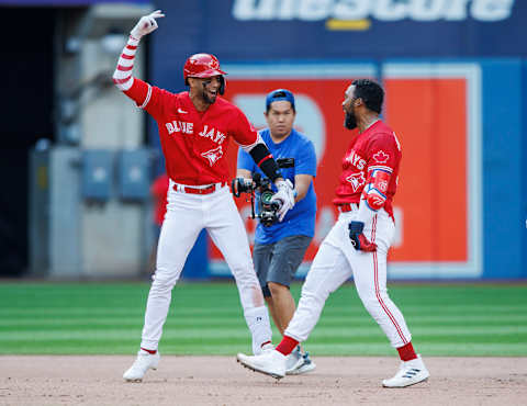 TORONTO, ON – JULY 16: Teoscar Hernandez #37 of the Toronto Blue Jays is mobbed by teammate Lourdes Gurriel Jr. #13 as they celebrate his walk-off RBI single against the Kansas City Royals at Rogers Centre on July 16, 2022, in Toronto, Canada. (Photo by Cole Burston/Getty Images)